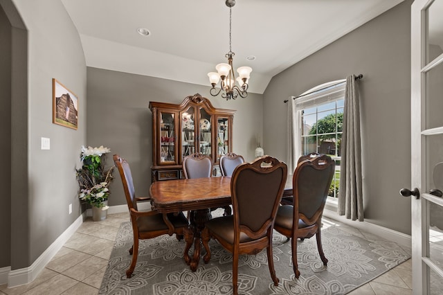 dining room featuring arched walkways, light tile patterned flooring, baseboards, an inviting chandelier, and lofted ceiling