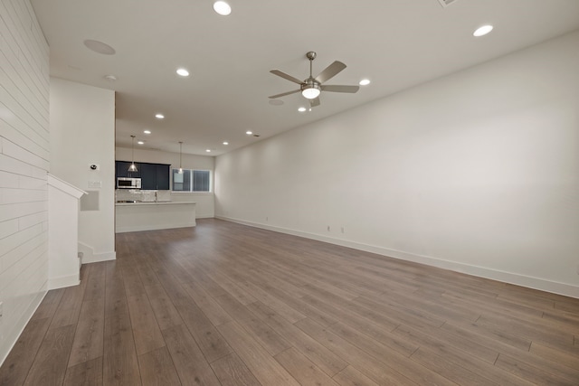unfurnished living room featuring baseboards, wood finished floors, recessed lighting, and ceiling fan