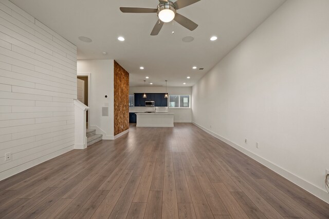 unfurnished living room featuring stairway, a ceiling fan, dark wood-style flooring, and recessed lighting