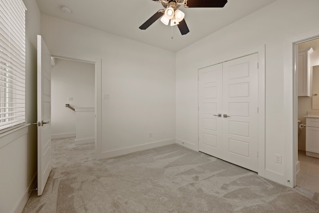 unfurnished bedroom with baseboards, a closet, and light colored carpet