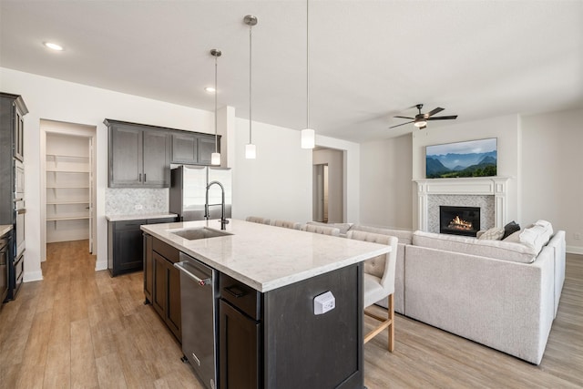 kitchen with light wood-type flooring, a sink, appliances with stainless steel finishes, and ceiling fan