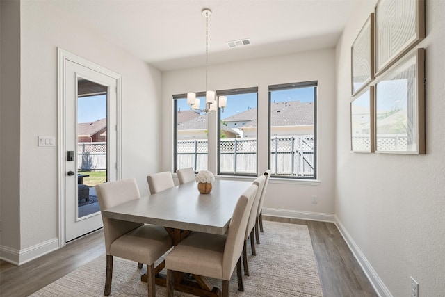 dining area with a chandelier, baseboards, visible vents, and dark wood-style floors