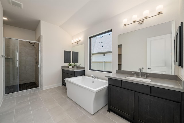 bathroom with a sink, a freestanding tub, a stall shower, and visible vents