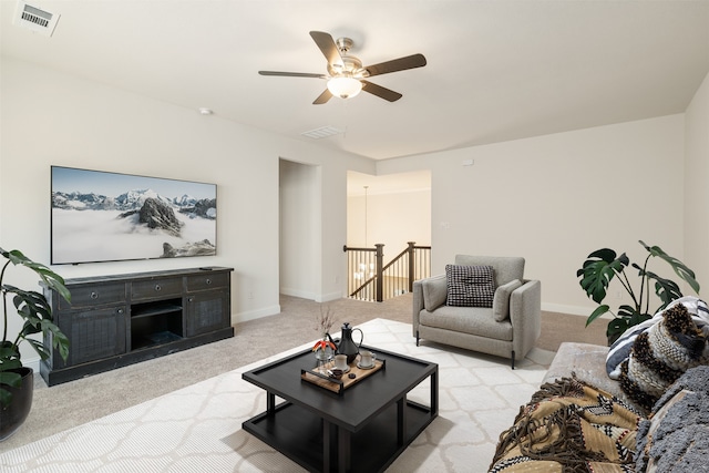 living area featuring carpet floors, ceiling fan, baseboards, and visible vents