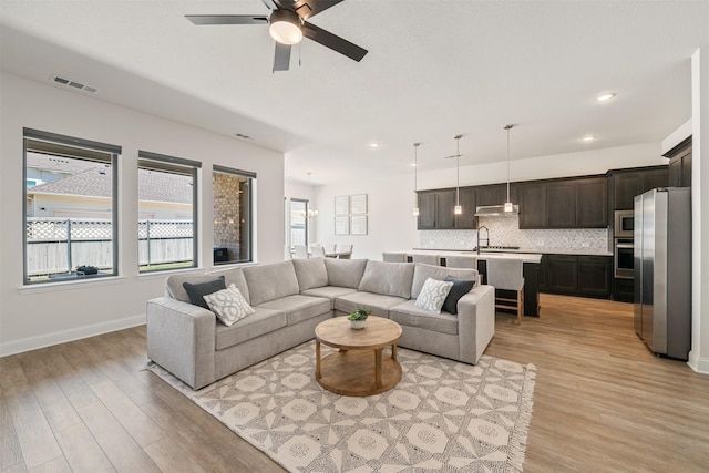 living area featuring light wood-type flooring, recessed lighting, and ceiling fan