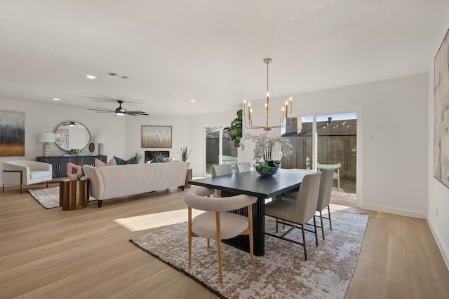 dining space featuring ceiling fan with notable chandelier, light wood-style floors, baseboards, visible vents, and recessed lighting