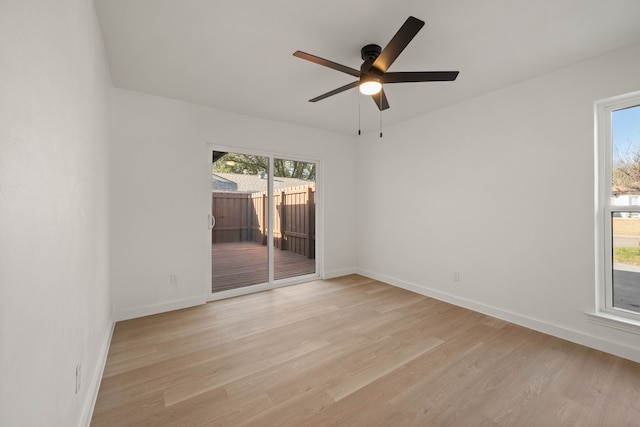 unfurnished room with baseboards, a ceiling fan, and light wood-style flooring