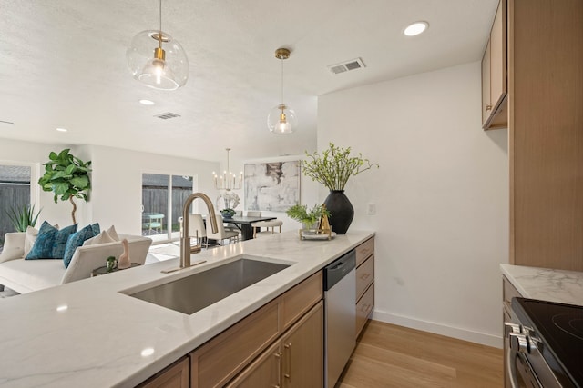 kitchen featuring stainless steel appliances, a sink, visible vents, light wood-style floors, and light stone counters