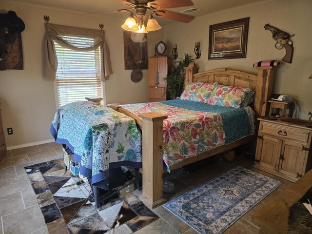bedroom with stone tile flooring, visible vents, baseboards, and ceiling fan