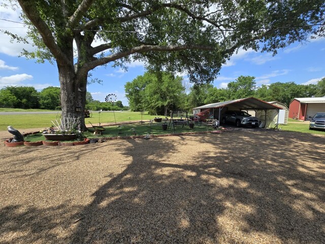 view of yard featuring driveway and a carport