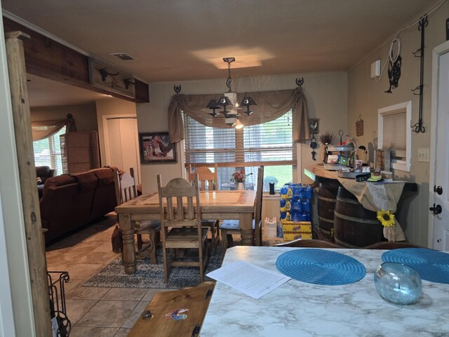 dining space with an inviting chandelier, light tile patterned flooring, and visible vents