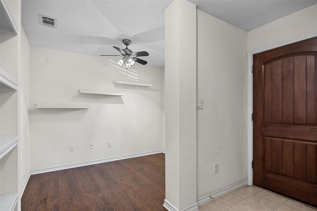 foyer featuring wood finished floors, baseboards, a ceiling fan, and visible vents