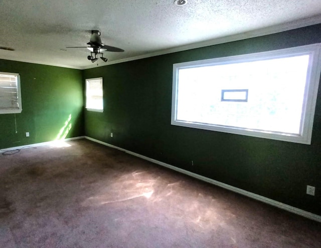 carpeted spare room featuring crown molding, a textured ceiling, ceiling fan, baseboards, and visible vents