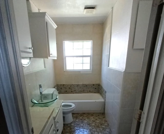 full bathroom featuring toilet, vanity, and a bathtub