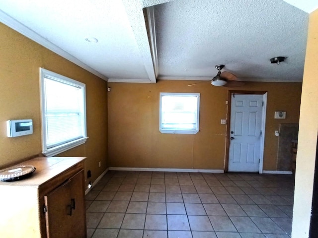 interior space featuring a textured ceiling, light tile patterned flooring, ceiling fan, baseboards, and ornamental molding