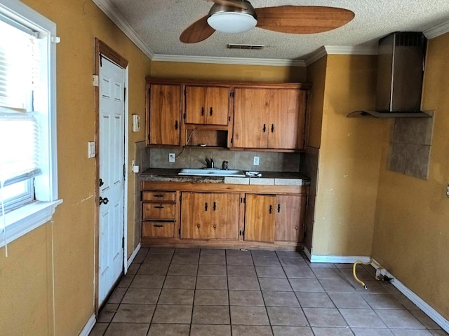 kitchen featuring brown cabinets, tasteful backsplash, visible vents, and a wealth of natural light