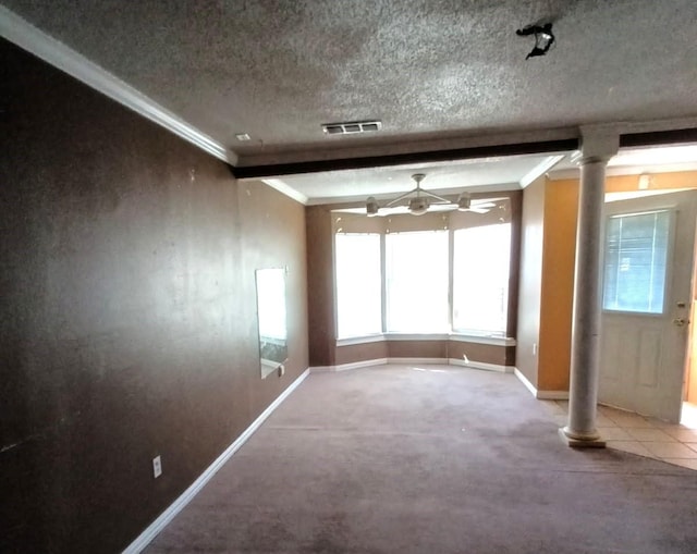 interior space with a textured ceiling, visible vents, baseboards, and ornamental molding