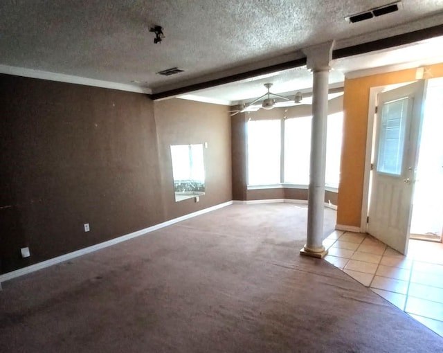 unfurnished room with carpet, decorative columns, visible vents, and a textured ceiling