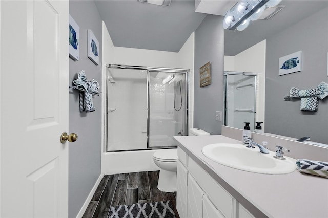511 Kiowa Dr W, Lake Kiowa, TX 76240 - bathroom featuring wood finished floors, toilet, vanity, baseboards, and bath / shower combo with glass door