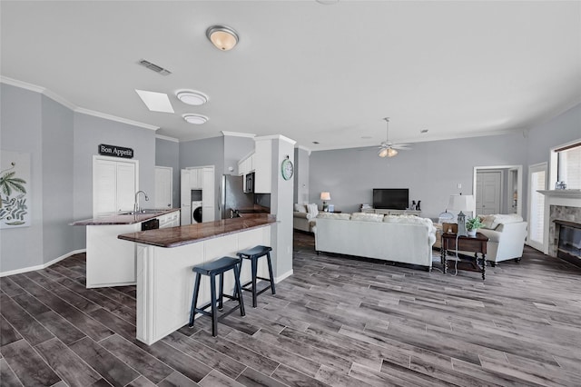 511 Kiowa Dr W, Lake Kiowa, TX 76240 - kitchen with a ceiling fan, a sink, open floor plan, a peninsula, and dark wood-type flooring