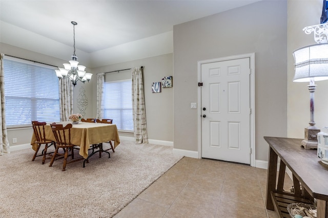 carpeted dining area featuring tile patterned floors, a chandelier, and baseboards