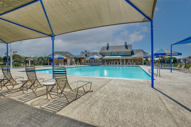 community pool featuring fence and a patio