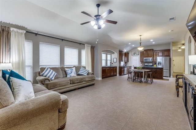 living room with visible vents, a ceiling fan, light tile patterned floors, and lofted ceiling