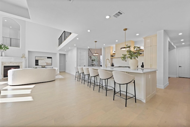 1750 Greenwood Ct, Prosper, TX 75078 - kitchen with a kitchen breakfast bar, baseboards, visible vents, recessed lighting, and a high end fireplace
