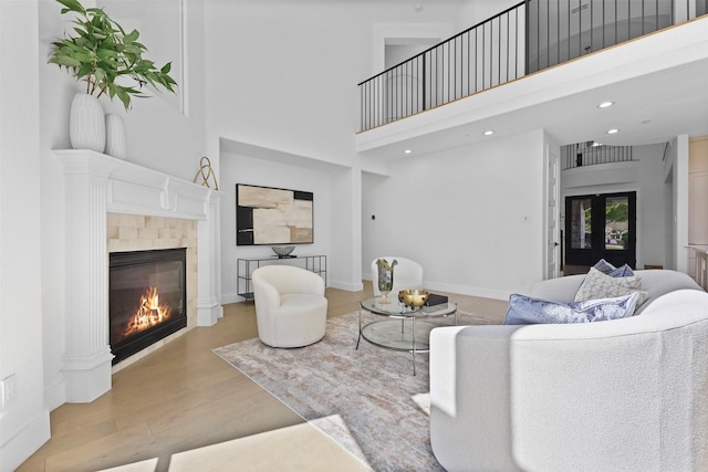 1750 Greenwood Ct, Prosper, TX 75078 - living area featuring a towering ceiling, a tiled fireplace, wood finished floors, and recessed lighting