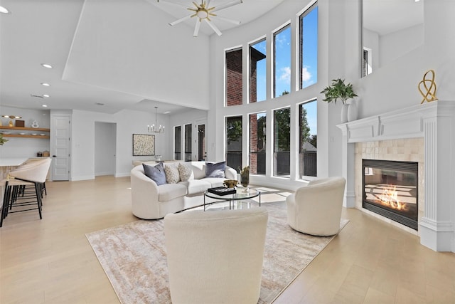 1750 Greenwood Ct, Prosper, TX 75078 - living area with light wood-style flooring, a chandelier, a towering ceiling, and a fireplace