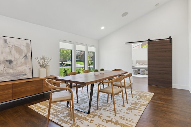 dining room featuring a barn door, recessed lighting, wood finished floors, baseboards, and high vaulted ceiling