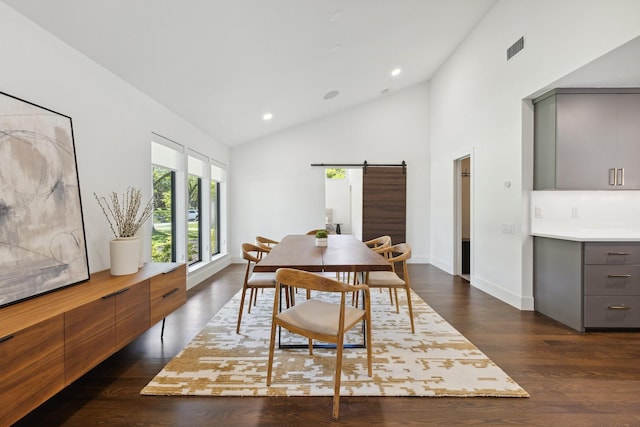 dining area featuring a barn door, recessed lighting, dark wood-style floors, visible vents, and high vaulted ceiling