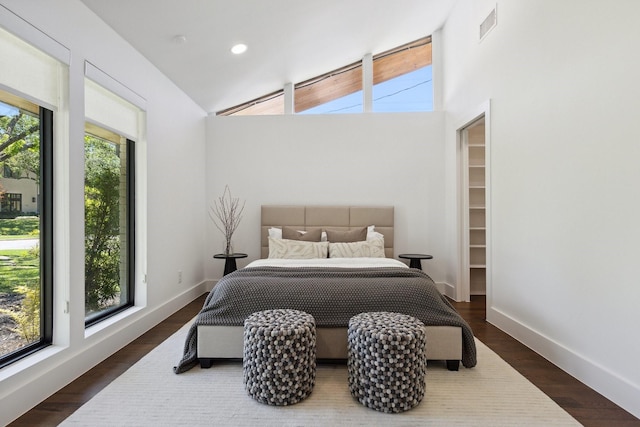 bedroom with baseboards, wood finished floors, multiple windows, and visible vents