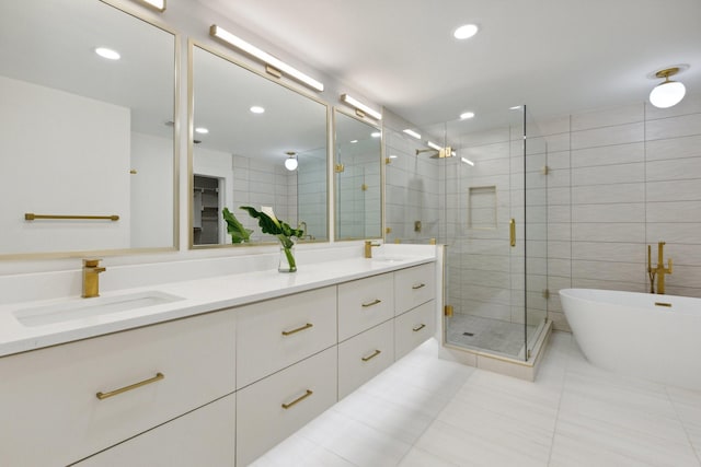 bathroom featuring tile patterned floors, a sink, double vanity, a stall shower, and a freestanding tub
