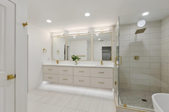bathroom with tile patterned floors, a stall shower, a freestanding tub, double vanity, and recessed lighting