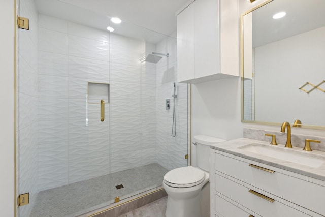 bathroom with a shower stall, toilet, vanity, and recessed lighting