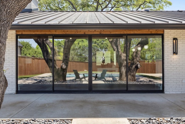 doorway to outside with brick wall and concrete floors