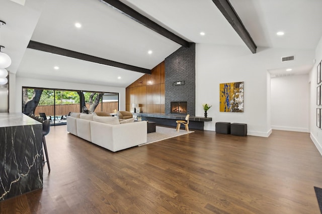 living room featuring recessed lighting, visible vents, lofted ceiling with beams, a large fireplace, and dark wood-style flooring