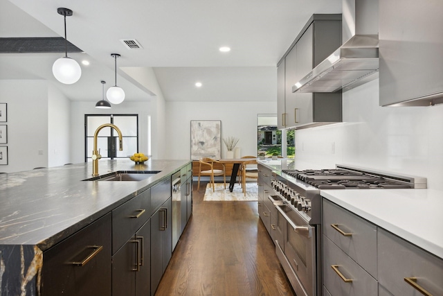 kitchen featuring wall chimney exhaust hood, stainless steel appliances, a sink, visible vents, and gray cabinetry