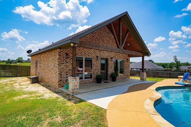 225 Clements Cir, Tatum, TX 75691 - back of property with a fenced backyard, a fenced in pool, brick siding, and a patio