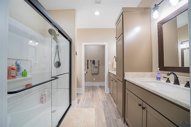 225 Clements Cir, Tatum, TX 75691 - full bathroom featuring a shower stall, wood finished floors, vanity, baseboards, and visible vents