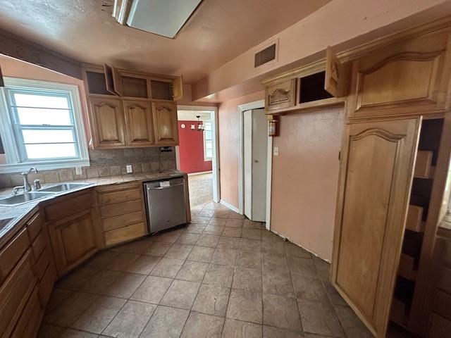 kitchen with dishwasher, decorative backsplash, a sink, and visible vents