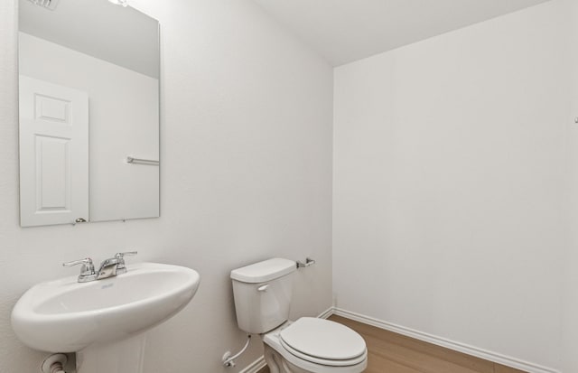 7200 Pederson Creek Way, Denton, TX 76208 - half bath featuring a sink, toilet, baseboards, and wood finished floors