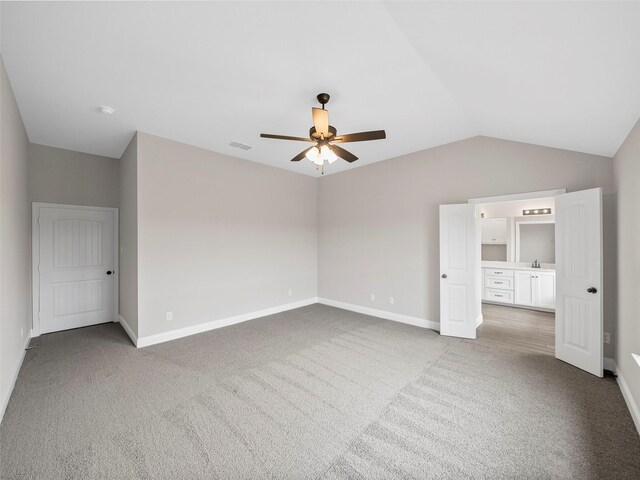 unfurnished bedroom featuring vaulted ceiling, visible vents, carpet flooring, and baseboards