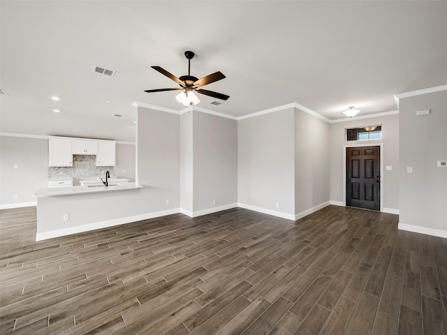 unfurnished living room featuring a ceiling fan, a sink, baseboards, dark wood-style flooring, and visible vents