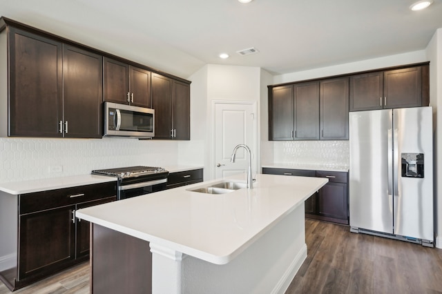 kitchen featuring visible vents, a sink, dark brown cabinetry, appliances with stainless steel finishes, and dark wood-style flooring