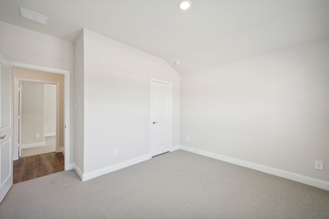 unfurnished bedroom featuring vaulted ceiling, dark carpet, baseboards, visible vents, and recessed lighting