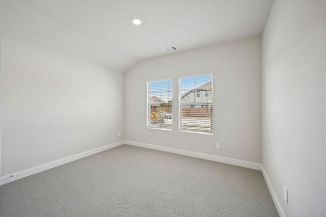spare room with recessed lighting, carpet, vaulted ceiling, visible vents, and baseboards