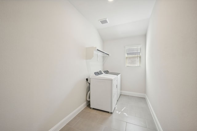 laundry area with washer and clothes dryer, laundry area, visible vents, light tile patterned floors, and baseboards