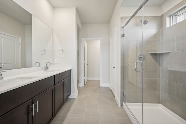 full bath with tile patterned flooring, a sink, double vanity, and a stall shower